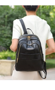 Detail view of a black PU leather backpack with geometric stitching and gold hardware