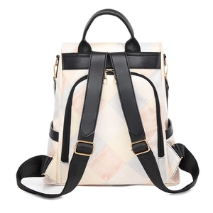 Detail view of anti-theft backpack with color block patterns and adjustable gold buckles