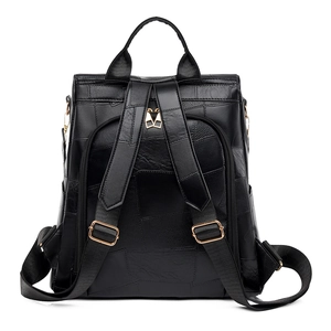 Minimalist black leather backpack with gold hardware and anti-theft pocket on back
