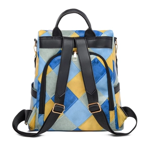 Detail of color block backpack featuring blue and yellow diamond patterns with gold zippers
