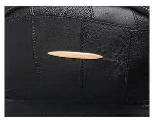 Detail of lychee pattern leather texture with golden leaf-shaped hardware and stitching