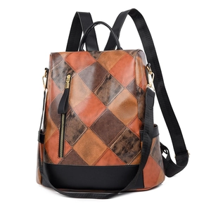 Detail of multi-tone brown patchwork pattern and golden zippers on fashion backpack