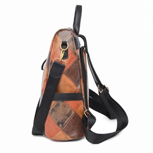Detail of vintage patchwork leather backpack showing side zipper and gold hardware hooks