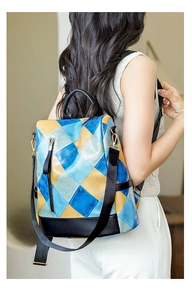 Detail view of anti-theft back pocket and adjustable fabric straps on patchwork backpack
