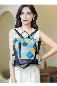 Detail of color-block quilted backpack with vertical metal zipper and gold-tone hardware