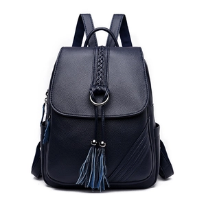 Front view of a dark blue leather backpack for women with fringe and woven details