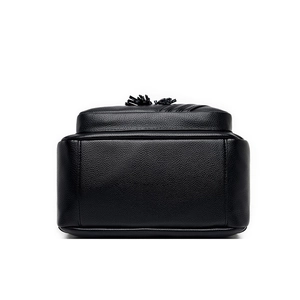 Detail of black lychee grain leather backpack with tassel zipper and smooth texture