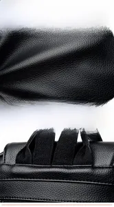 Detail of black lychee grain leather texture and reinforced stitching on backpack straps