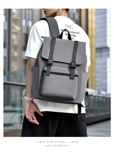Outdoor shot of a grey minimalist waterproof backpack with black buckle straps and flap