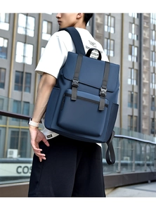 Detail of dark blue waterproof laptop backpack showing front buckle and wide shoulder straps