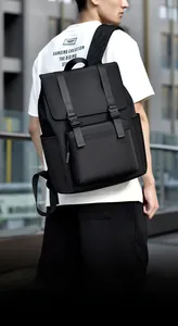 Outdoor view of a black large capacity laptop backpack with dual buckle flap closure