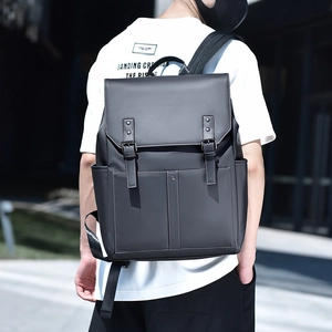 Vue extérieure d'un homme portant un grand sac à dos noir mat à boucles et lanières