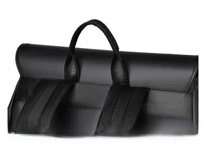 Close-up of the black matte backpack showing reinforced top handle and padded shoulder straps