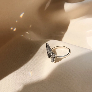 Adjustable 925 sterling silver butterfly ring with vintage finish on fabric background