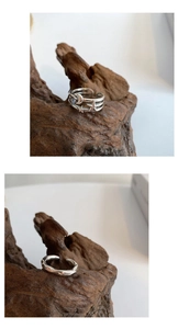Detailed view of layered star and moon silver rings on dark wood for retro aesthetic