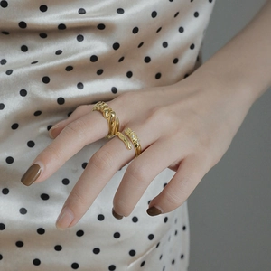Golden twisted rope ring and pavé zircon open ring on female model hand