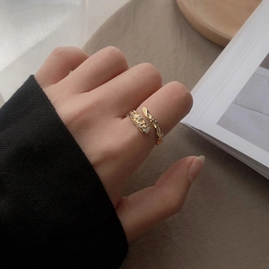 Detail of gold hammered ring with zircon accents shown on a hand in a chic setting