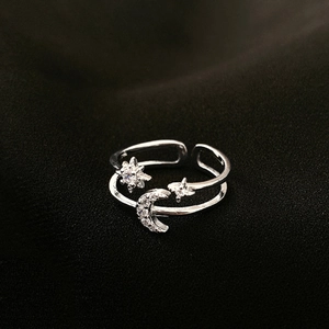 Minimalist silver moon and star open ring with sparkling crystals on black background