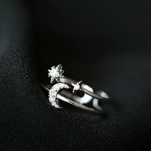 Macro detail of silver crescent moon and stars open ring with shimmering white zircons