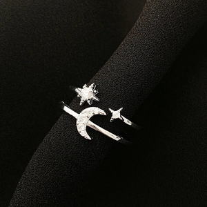 Detailed view of silver star and moon ring with sparkling cubic zirconia on fabric