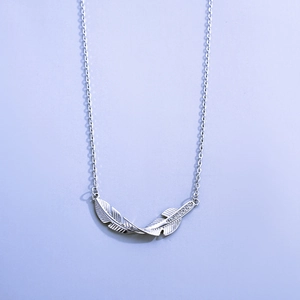 Detail of s925 silver feather pendant with sparkling stones and fine chain necklace