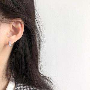 Close-up of silver square hoop earrings with sparkling cubic zirconia on female model