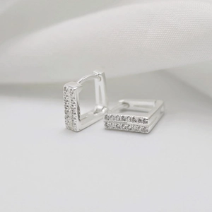Macro shot of silver square hoop earrings with double-row sparkling cubic zirconia
