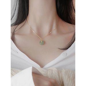 Elegant green jade pendant necklace on model with minimalist gold chain for women
