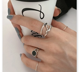 Gros plan sur un ensemble de 4 bagues en argent 925 avec un détail en émail noir