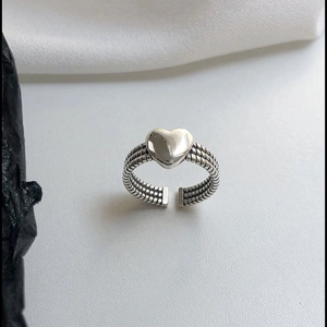 Detailed view of s925 silver heart ring featuring a triple-layer braided texture band