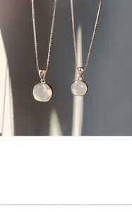 Detailed view of 925 sterling silver necklace with two round white chalcedony pendants
