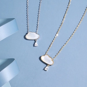 Detail of cloud-shaped necklaces with water drop zircon and white shell inlay in gold and silver