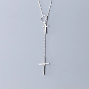 Macro detail of silver Y-shaped double cross pendant necklace with polished chain