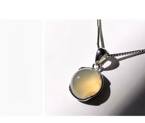 Macro shot of 925 silver necklace with a round translucent chalcedony gemstone pendant
