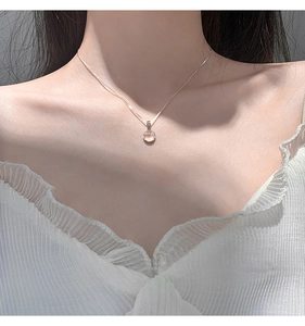Close-up of 925 sterling silver necklace with a round pink chalcedony pendant on a model