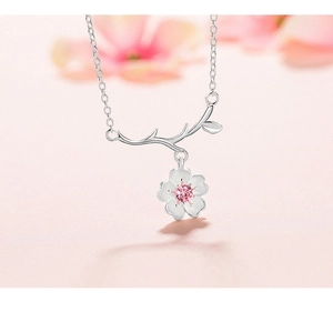 Close-up of s925 silver cherry blossom pendant with pink gemstone on a delicate chain