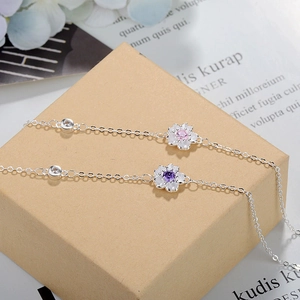 Detailed macro of silver cherry blossom bracelets with pink and purple zircon accents