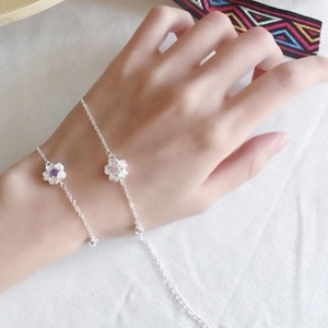 Detailed close-up of cherry blossom bracelets with purple and pink gemstones on wrist