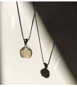 Detail of 925 silver necklace with white chalcedony pendant in natural light