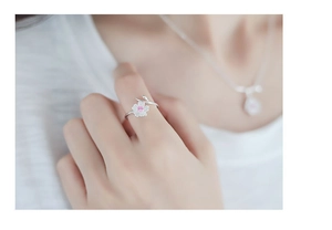 Close-up of adjustable cherry blossom ring with pink gemstone and silver petals