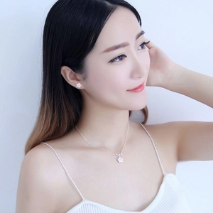 Detail of elegant cherry blossom necklace and earrings set worn by a model