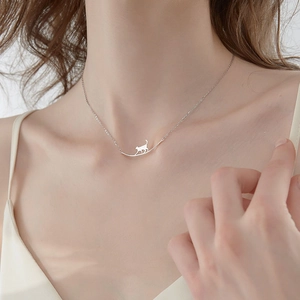 Collier minimaliste en argent avec silhouette de chat sur barre courbe pour femme porté