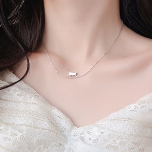 Gros plan détaillé d'un collier chat en argent avec barre incurvée porté par un mannequin
