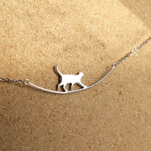 Collier minimaliste chat en argent avec barre polie sur un fond en liège chaud