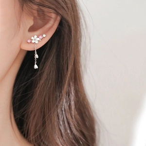 Detail of 925 silver flower ear cuff with shell petals and long tassel earring