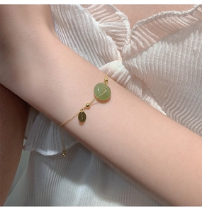 Detail of Nephrite Jade Ping'an buckle bracelet with 18K gold plated silver chain on wrist