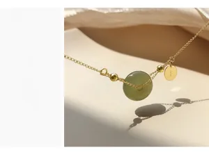 Macro shot of S925 gilded silver necklace with Hetian jade pendant and S925 tag