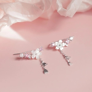 Detail of 925 silver cherry blossom ear crawlers with shell petals and fringe tassels