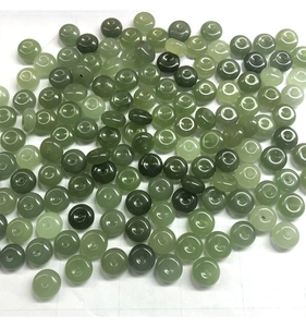 Macro shot of assorted green Hetian jade flat round beads with polished oily luster