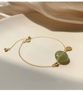 Macro detail of Hetian jade pendant with 18K gold plated silver chain and brand tag